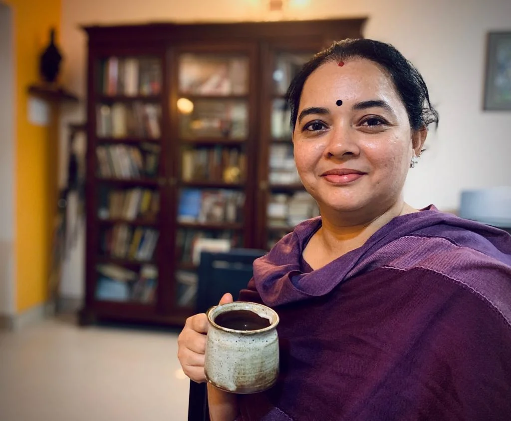 Suchitra Inamdar holding tea in her practice space